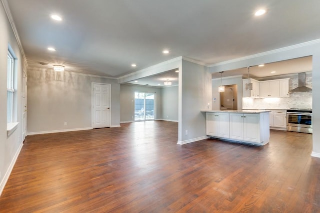 kitchen featuring stainless steel range, white cabinetry, wall chimney range hood, backsplash, and kitchen peninsula