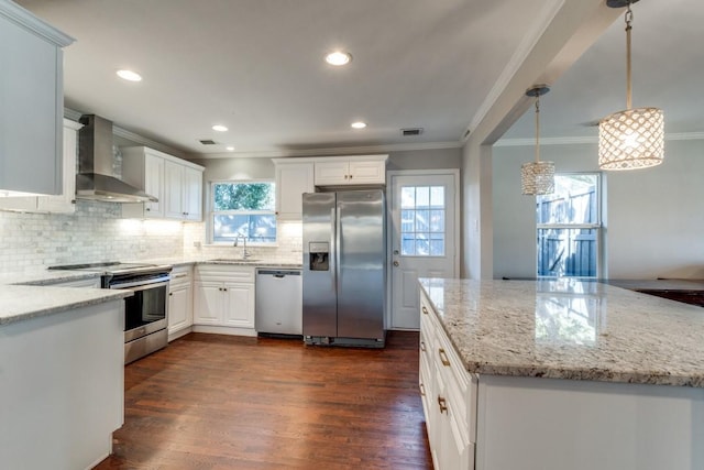 kitchen featuring hanging light fixtures, white cabinetry, light stone countertops, wall chimney range hood, and stainless steel appliances