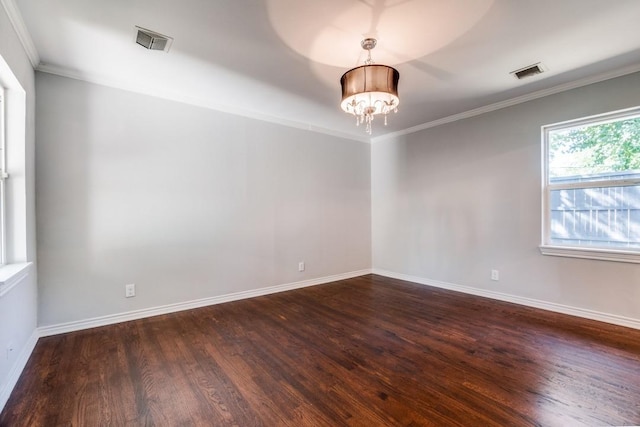 unfurnished room with dark hardwood / wood-style flooring, ornamental molding, and a notable chandelier