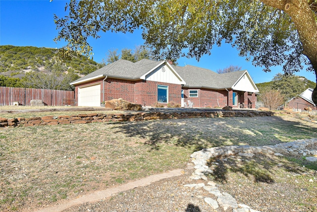 view of front of home with a mountain view, a front yard, and a garage