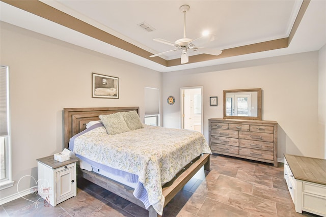 bedroom with ceiling fan and a tray ceiling