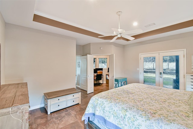 bedroom featuring multiple windows, french doors, a tray ceiling, and access to exterior