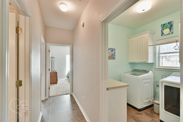 clothes washing area with light tile patterned flooring, cabinets, and separate washer and dryer