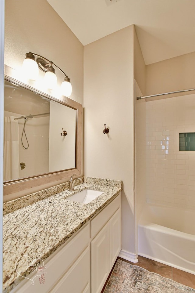 bathroom featuring vanity, tile patterned flooring, and tiled shower / bath