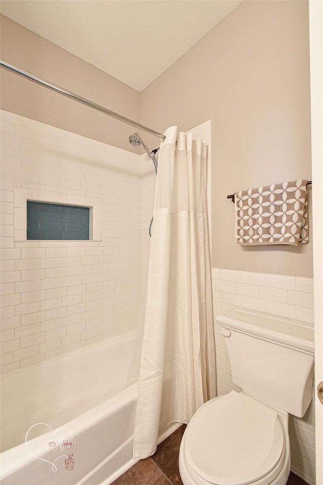 bathroom with shower / tub combo with curtain, toilet, tile walls, and tile patterned floors