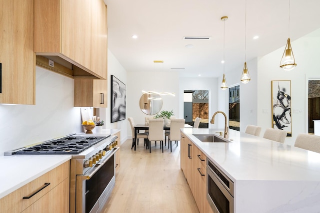 kitchen with light brown cabinetry, a large island, sink, pendant lighting, and stainless steel appliances