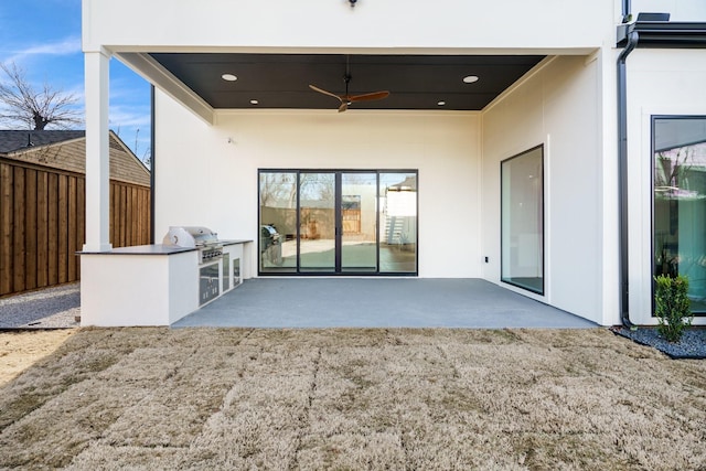 rear view of property featuring ceiling fan, a patio, and exterior kitchen