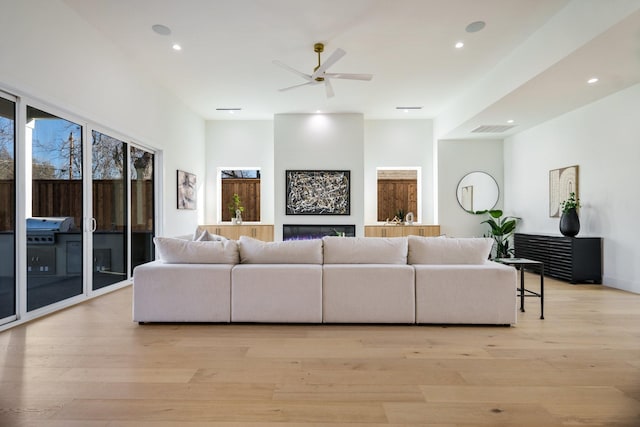 living room featuring light hardwood / wood-style floors and ceiling fan