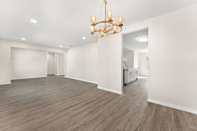 empty room featuring sink, an inviting chandelier, and dark hardwood / wood-style flooring