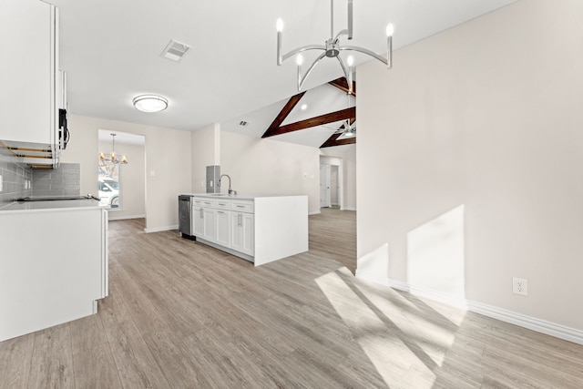 kitchen featuring ceiling fan with notable chandelier, white cabinetry, decorative backsplash, hanging light fixtures, and lofted ceiling with beams