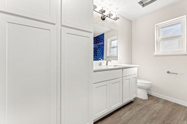 bathroom with vanity, toilet, and wood-type flooring