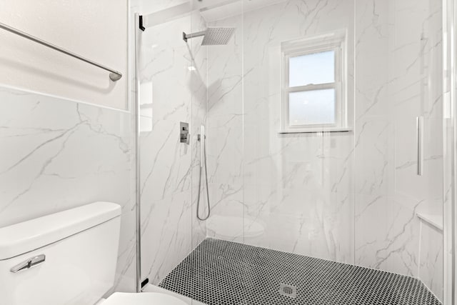 bathroom featuring a tile shower and toilet