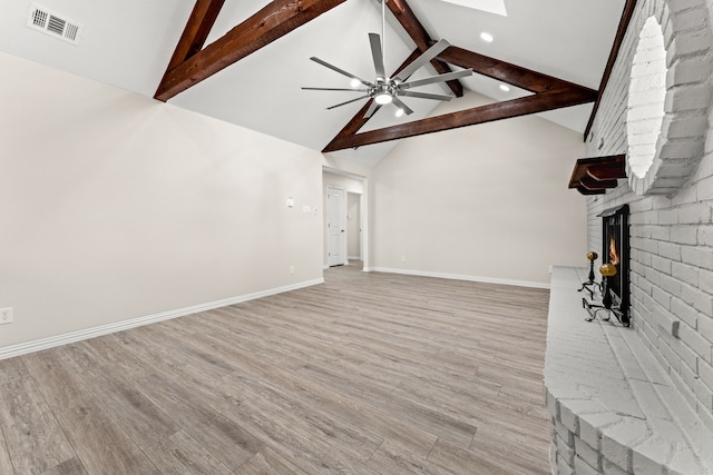 unfurnished living room with ceiling fan, vaulted ceiling with skylight, light wood-type flooring, and a fireplace