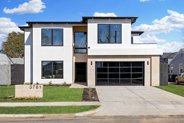 contemporary home featuring a garage and a front lawn