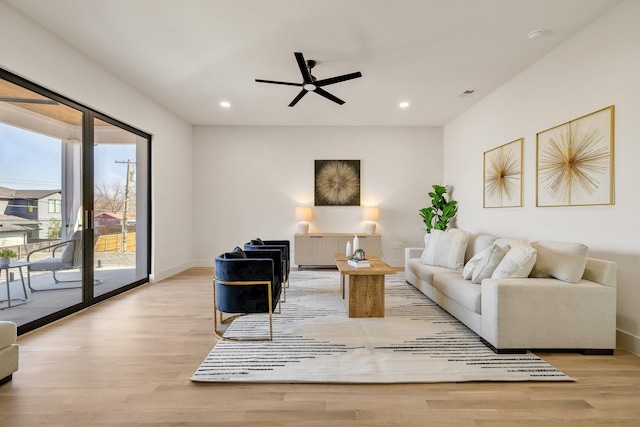 living room with ceiling fan and light hardwood / wood-style flooring