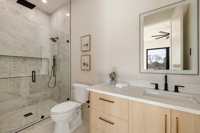 bathroom with a shower with door, vanity, and toilet