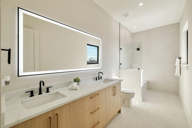 bathroom with vanity, tile patterned flooring, toilet, and tiled shower