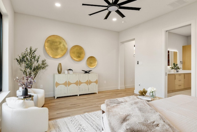 bedroom featuring ceiling fan, ensuite bath, and light hardwood / wood-style flooring