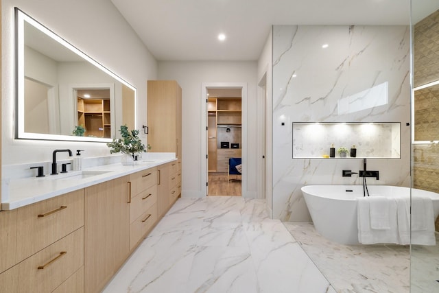 bathroom with vanity, a bathtub, and tile walls