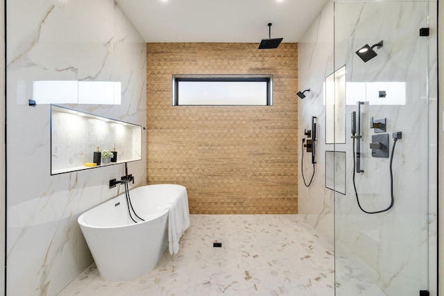 bathroom featuring shower with separate bathtub and tile walls