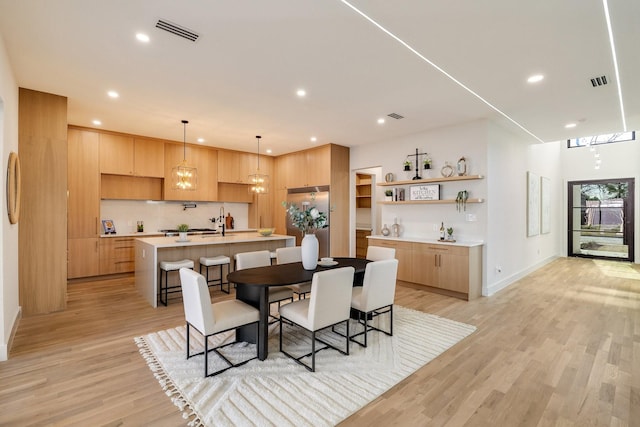 dining space featuring sink and light hardwood / wood-style flooring