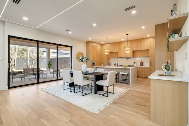 dining area featuring sink and light hardwood / wood-style floors