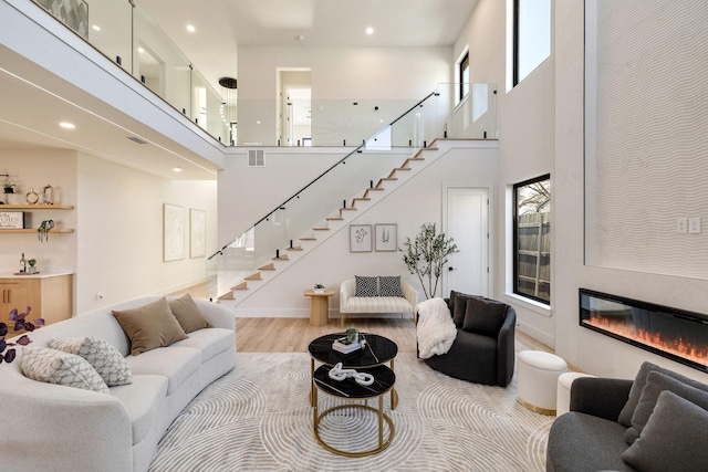 living room with light hardwood / wood-style floors and a high ceiling