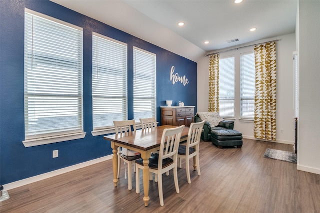 dining area with hardwood / wood-style flooring and vaulted ceiling