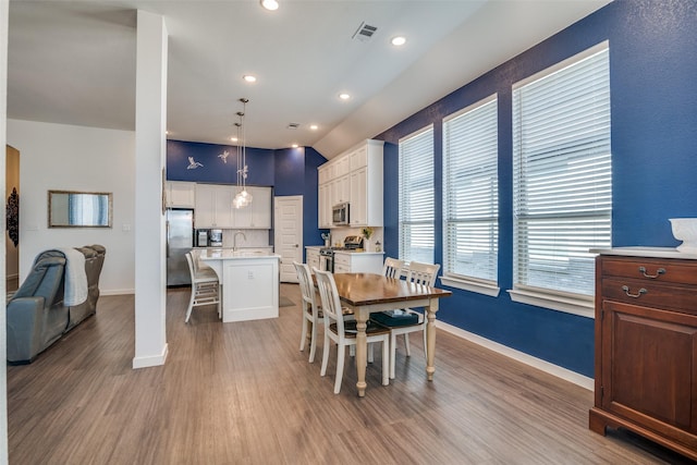 dining space with wood-type flooring and sink