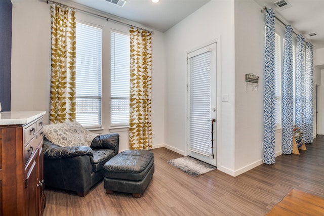 living area featuring hardwood / wood-style flooring and a healthy amount of sunlight