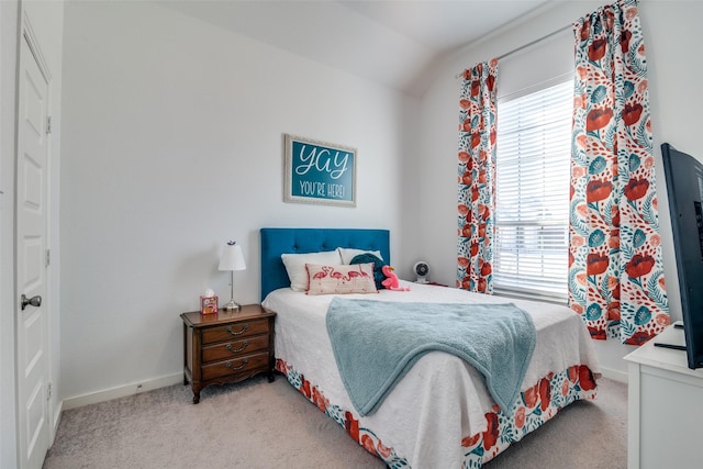 bedroom with multiple windows, vaulted ceiling, and light colored carpet