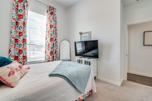 bedroom featuring light colored carpet and lofted ceiling