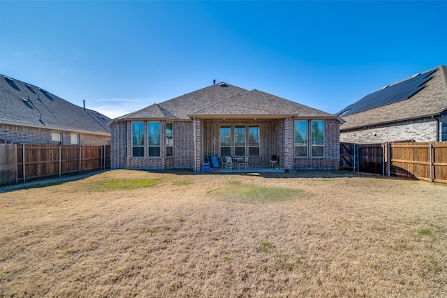 back of house with a patio area and a lawn