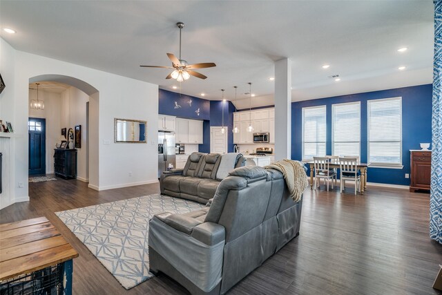 living room featuring ceiling fan and dark wood-type flooring