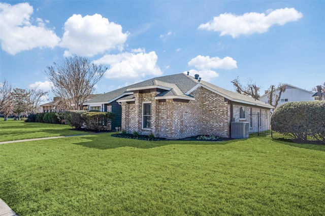 view of side of property with a lawn and central AC