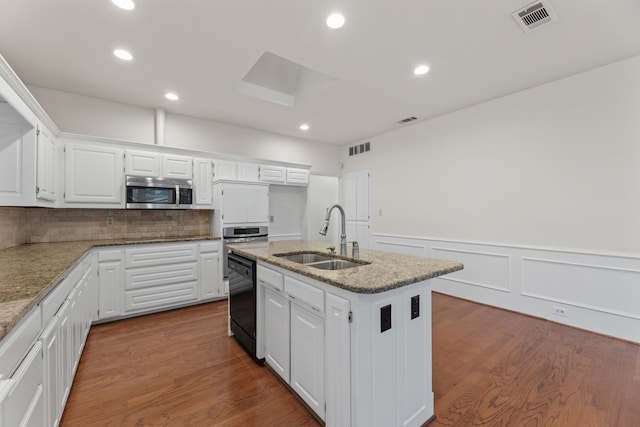 kitchen featuring hardwood / wood-style floors, dishwasher, a kitchen island with sink, sink, and white cabinets