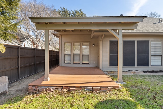 rear view of house with a lawn and a deck