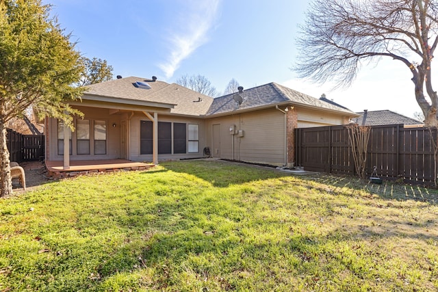 back of property with a lawn and a deck