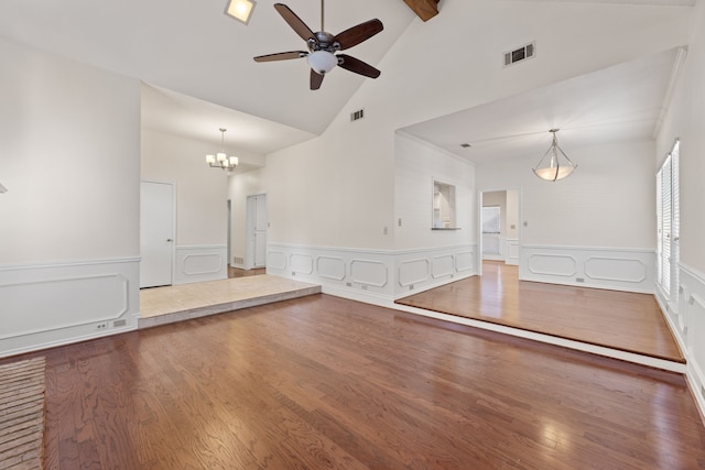 unfurnished living room with hardwood / wood-style flooring, beamed ceiling, ceiling fan with notable chandelier, and high vaulted ceiling