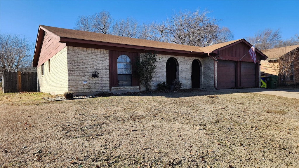 ranch-style home featuring a garage and a front lawn