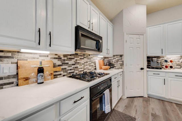 kitchen featuring white cabinetry, black appliances, and tasteful backsplash