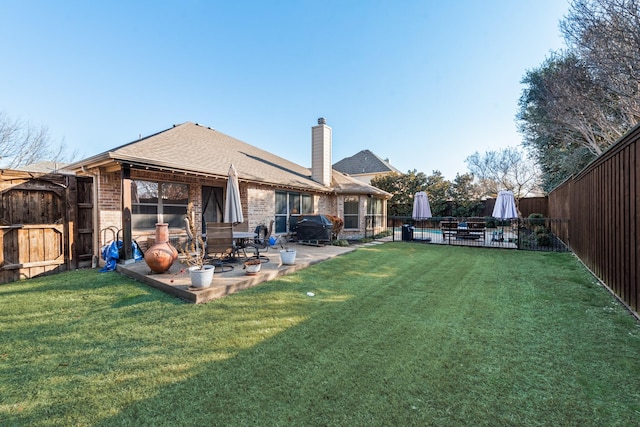 rear view of property with a patio and a yard