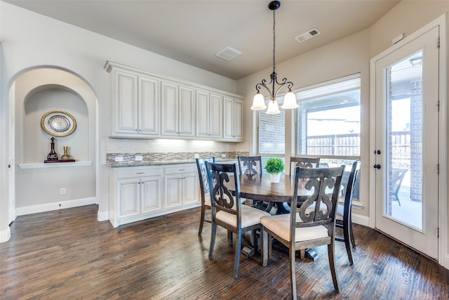 dining area featuring an inviting chandelier and dark hardwood / wood-style floors