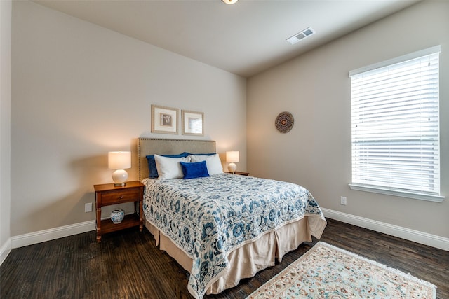 bedroom with dark hardwood / wood-style floors