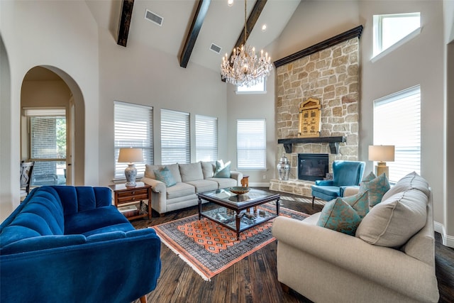 living room with a stone fireplace, a high ceiling, dark wood-type flooring, and beamed ceiling