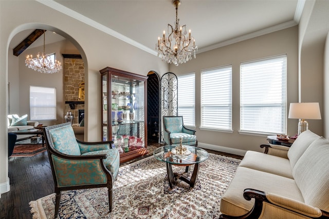 living room with a notable chandelier, crown molding, dark wood-type flooring, and a fireplace