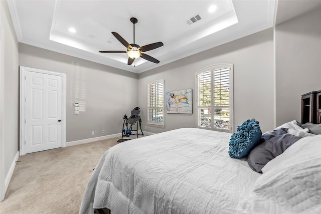 carpeted bedroom with ceiling fan, ornamental molding, and a tray ceiling