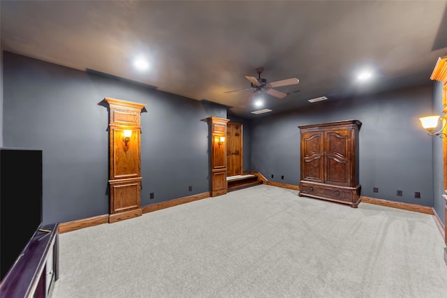 carpeted home theater room with ceiling fan