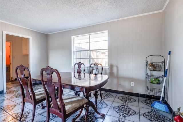 dining area with a textured ceiling, ornamental molding, and wooden walls