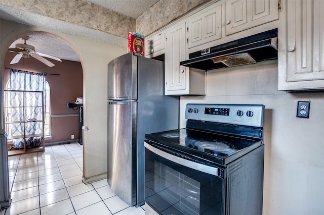 kitchen with ceiling fan, a textured ceiling, appliances with stainless steel finishes, and light tile patterned flooring